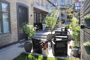 a patio with potted plants and a staircase at Hotel Petite B&B in Haderslev