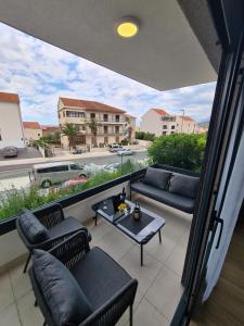 a balcony with couches and a table and a view at Apartman Kamena 67 A in Tučepi