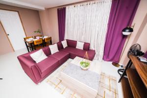 een woonkamer met een paarse bank voor een raam bij JSB Suites in Dipolog