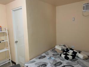 a bedroom with a bed with a black and white blanket at La Riesa Dorm in Tarlac