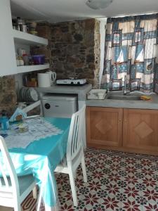 a kitchen with a table with chairs and a sink at Popi Studios in Astypalaia Town
