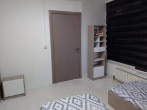 a bedroom with a bed and a closet with a window at Apartman ZAFIROVI in Gevgelija