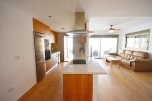 cocina grande y sala de estar con sofá en HE Villamartin Gardens, en Orihuela