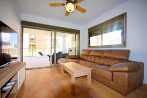 Una sala de estar con un sofá y un ventilador de techo. en HE Villamartin Gardens, en Orihuela