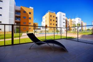 un banco en un balcón con edificios en el fondo en HE Villamartin Gardens, en Orihuela