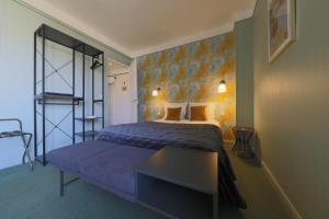 - une chambre avec un grand lit et un banc bleu dans l'établissement Hôtel Azur, à Reims