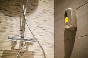 a shower in a bathroom with a phone on the wall at Deluxe 35m2 City Center Suite - with Views in Den Bosch