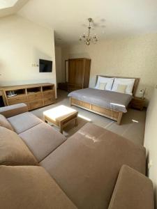 a living room with a bed and a couch at PROSECCO RESIDENCE MARKO in Valtice