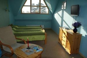 ein blaues Zimmer mit einem Bett und einem Tisch und einem Tisch sidx sidx in der Unterkunft Atpūtas komplekss "Pūķarags" in Pape