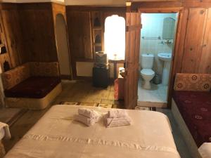 a bedroom with a bed and a bathroom with a toilet at Paphlagonia Yoruk Muratoglu Konak in Safranbolu