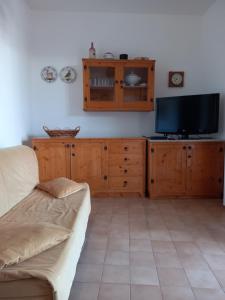 a living room with a couch and a flat screen tv at Villetta indipendente - Torre dell' Orso in Torre dell'Orso