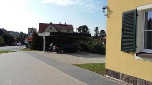 a car parked in a parking lot next to a house at Genesungsort Landhaus Dammert in Oppach