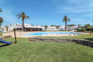 una piscina con palmeras y un complejo en Casa O12, en Vilamoura