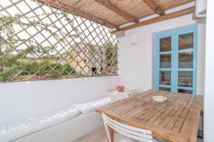 a dining room with a wooden table and a window at Charming house in San Pantaleo in Olbia