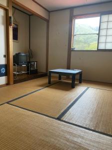 ein Zimmer mit einem Tisch in der Mitte eines Zimmers in der Unterkunft Guest House Shiroikiseki in Toyama