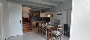 ein Esszimmer mit einem Tisch und Stühlen sowie eine Küche in der Unterkunft La Loge de Gabrielle in Montlouis-sur-Loire