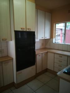 a small kitchen with a black refrigerator in it at 4ways Youth Hostel in Johannesburg