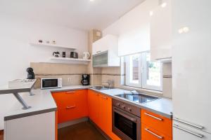 a kitchen with orange and white cabinets and a sink at Lorena Suite with private pool in Dubrovnik