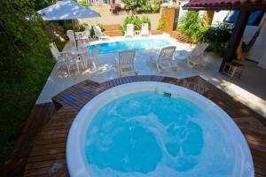 uma piscina de mergulho com cadeiras e uma mesa ao lado de uma piscina em Beach House Floripa em Florianópolis