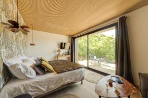 1 dormitorio con cama y ventana grande en La Possibilité d'une Ile, en Apt