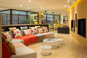 a living room filled with furniture and a large window at Citadines Ramblas Barcelona in Barcelona