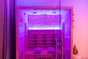 a purple bathroom with a shower with purple lights at Spa Edelweiss in Dijon
