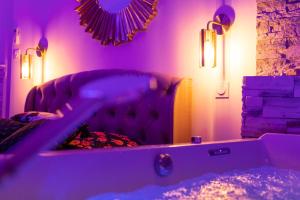 ein Wohnzimmer mit einem Sofa mit lila Beleuchtung in der Unterkunft Spa Edelweiss in Dijon