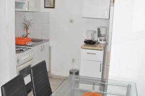 a small kitchen with a glass table and a stove at Apartment 4988-1 in Pula