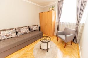 ein Wohnzimmer mit einem Sofa und einem Stuhl in der Unterkunft City center de Lux apartment in Bar