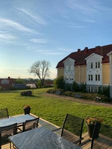 eine Terrasse mit Tischen und Stühlen und ein Haus in der Unterkunft Halltorps Gästgiveri in Halltorp