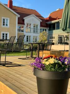 una maceta de flores sentada en una terraza de madera en Halltorps Gästgiveri, en Halltorp