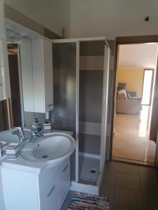a bathroom with a white sink and a shower at Apartments Vellico in Bale