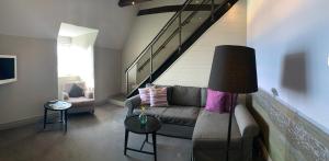 a living room with a couch and a staircase at Halltorps Gästgiveri in Borgholm +34 photos