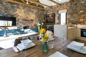 Laundry Cottage, River Doon fishing في آير: مطبخ مع طاولة خشبية مع إناء من الزهور