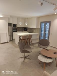 a kitchen with chairs and a table and a counter at Pink rose luxury and comfort apartment at the centre of Preveza in Preveza