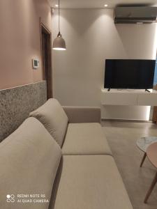a living room with a couch and a flat screen tv at Pink rose luxury and comfort apartment at the centre of Preveza in Preveza