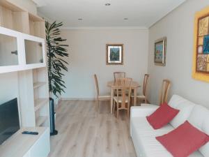 - un salon avec un canapé blanc et une table dans l'établissement Apartamento Argandona-Gijon, à Gijón