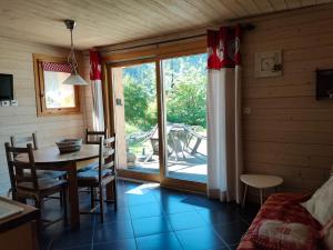 a dining room with a table and chairs and a window at la ratavelaiza in Champagny-en-Vanoise