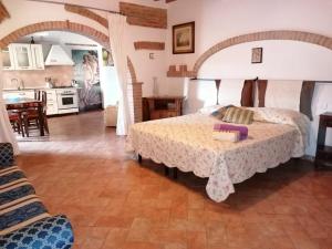 a bedroom with a large bed and a kitchen at Villa Nobile Cortona B&B in Cortona