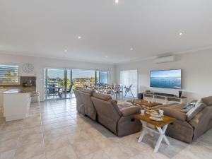 a living room with a couch and a table at Jackson View luxury holiday property with water views in Salamander Bay
