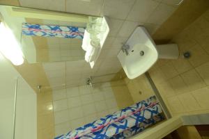 La salle de bains est pourvue de toilettes, d'un urinoir et d'un lavabo. dans l'établissement Argo Hotel, à Perama