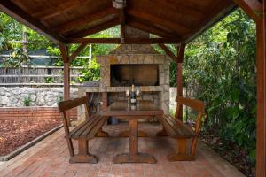 a wooden table with two chairs and a stone fireplace at Holiday Home Relax - Mošćenička Draga in Mošćenička Draga