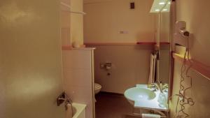 a small bathroom with a sink and a toilet at Hôtel Arbois Bettex in Saint-Gervais-les-Bains