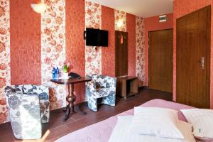 a hotel room with a bed and a table and chairs at Hotel Horda in Słubice