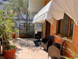 an outdoor patio with chairs and an umbrella at Villa Alba Boutique Hotel in Pescara