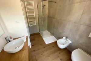 La salle de bains est pourvue d'un lavabo, de toilettes et d'une douche. dans l'établissement Design Apartment in the heart of Bolzano, à Bolzano