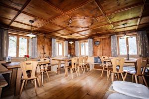 jadalnia z drewnianą podłogą, stołami i krzesłami w obiekcie Hus 172 w mieście Gaschurn