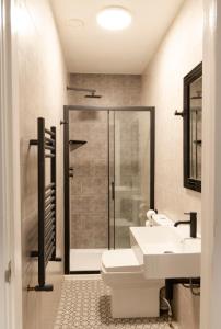 uma casa de banho com um chuveiro, um WC e um lavatório. em Comfotel GRN em Londres