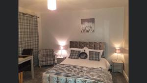 a bedroom with a bed and a desk and two lamps at Country House and Spa in Coleraine