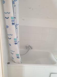 uma cortina de chuveiro numa casa de banho ao lado de uma banheira em Les prussiens em Wavre